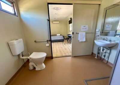Bathroom of family cabin showing toilet, sink and entrance.